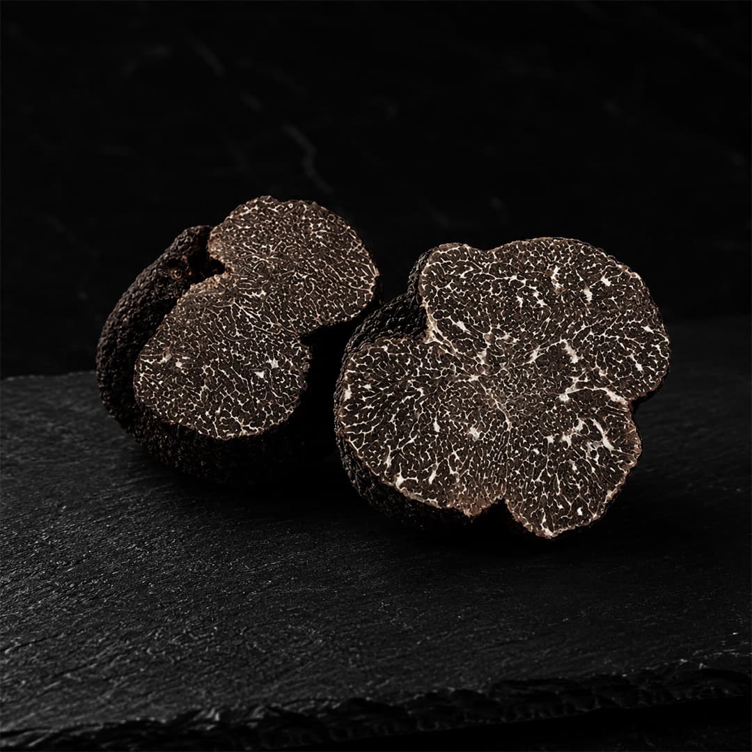 Two halved black truffles showing marble interior